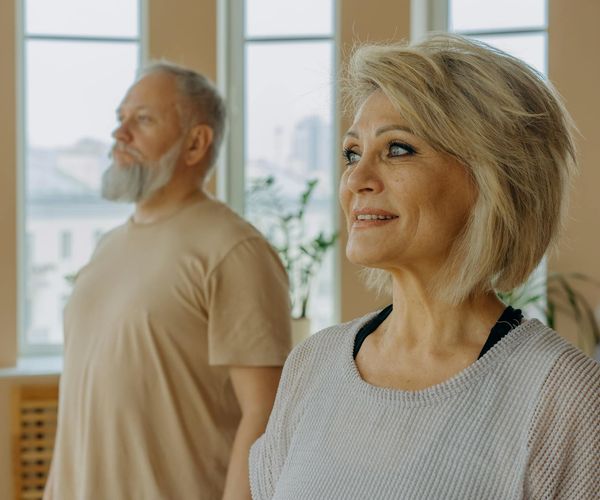 Group of people of different ages in a beginner yoga class.